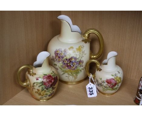 THREE ROYAL WORCESTER BLUSH IVORY FLAT BACKED JUGS, each florally decorated, gilding to handles and borders, shaped No.1094, 