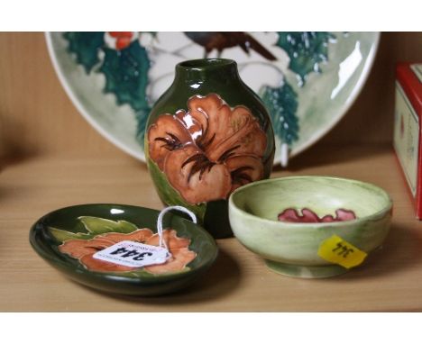 THREE PIECES MOORCROFT POTTERY, to include 'Hibiscus' oval pin dish and bud vase, height approximately 9cm, both on green gro