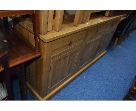A MODERN LIGHT OAK SIDEBOARD WITH THREE DRAWERS OVER THREE CUPBOARD DOORS, 165cm long
