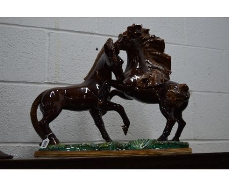 A LARGE CERAMIC FIGURE GROUP OF TWO PRANCING HORSES ON A RECTANGULR BASE, brown and iridescent green glazes, length 84cm