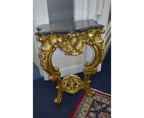 A GILTWOOD CONSOLE TABLE, white veined black marble serpentine top, on a foliate carved cabriole base, linked by a shell shap