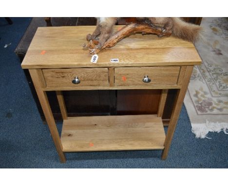 A SMALL LIGHT OAK HALL TABLE, with two drawers and undershelf