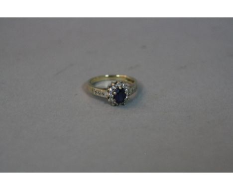 A LATE 20TH CENTURY 9CT GOLD DIAMOND AND SYNTHETIC SAPPHIRE CLUSTER RING, an oval cluster ring with diamond set shoulders, es