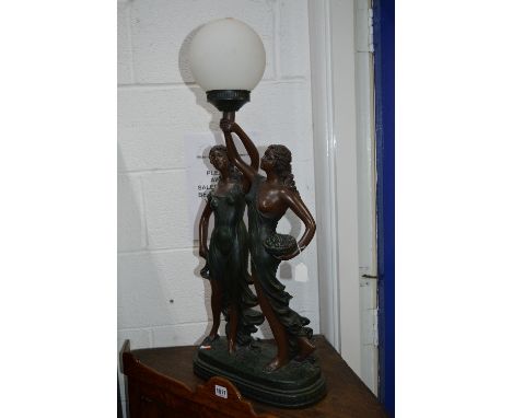 A MODERN RESIN TABLE LAMP, with two semi clad females holding a light aloft with shade