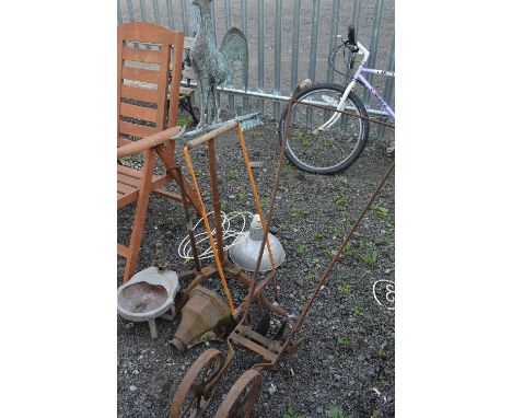 A VINTAGE CAST IRON PLOUGH, two metal stands, cast iron hopper, a weather vane, etc