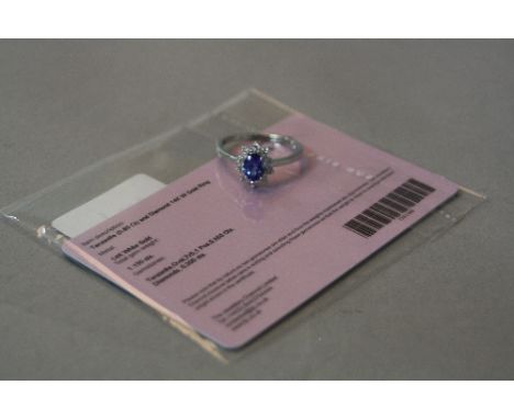 A 14K WHITE GOLD TANZANITE AND DIAMOND CLUSTER RING, ring size R, approximate weight 3.2 grams, (certificate)