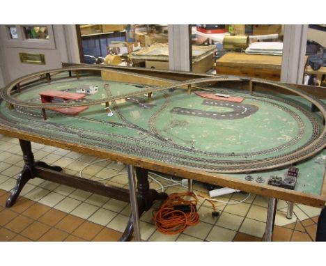 A OO GAUGE THREE RAIL MODEL RAILWAY LAYOUT, comprising two ovals and figure of eight track layout, with some remaining buildi