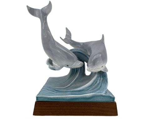 Tony Morris for Poole Pottery, leaping dolphin group, modelled over waves and mounted on a wooden base, H29cm. This model is 
