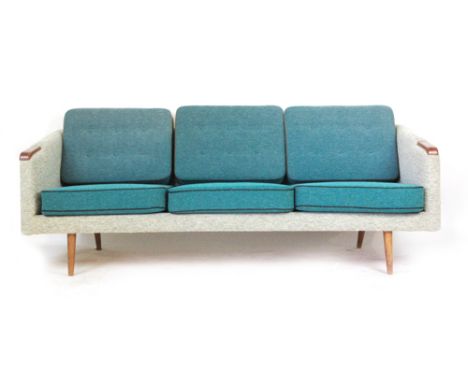 A Danish 1960/70's upholstered three seater sofa with exposed teak arms and tapering legs   CONDITION REPORT:  Fading, struct