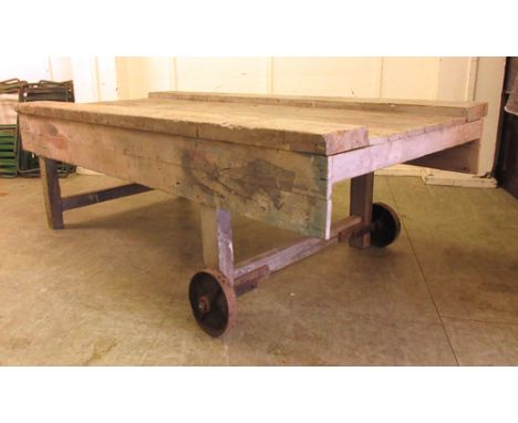Industrial Design: a large pine carpenter's work bench, the rear end with two cast metal wheels, 236 x 123 cm