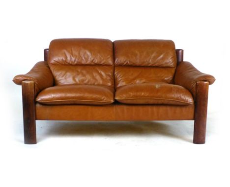 A Swedish brown leather two seater sofa with an exposed stained beech frame by Ulferts   CONDITION REPORT:  Some cracking to 