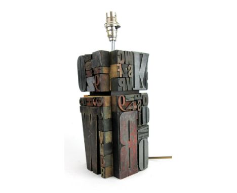 A mid-century table lamp constructed of letter-stamps, h. 36 cm    CONDITION REPORT:  No guarantee to working order. Several 