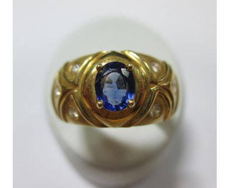 A tanzanite and diamond ring, the tapered convex band set to the centre with an oval cut tanzanite flanked to each side by th