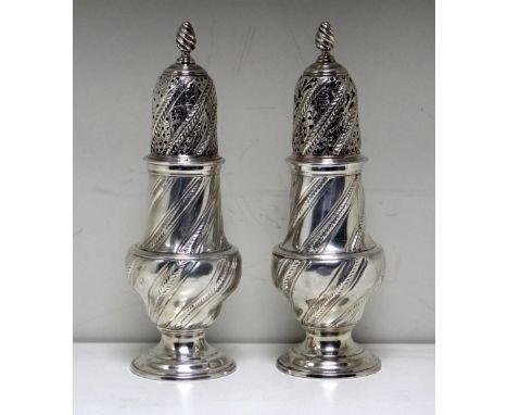 A pair of George III silver casters, by John Delmester, London 1762, each of baluster shape, wrythen fluted, the covers decor