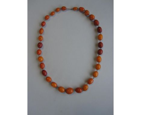 A vintage butterscotch amber bead necklace, the opaque oval beads of variable colour, consistency and slightly variable shape