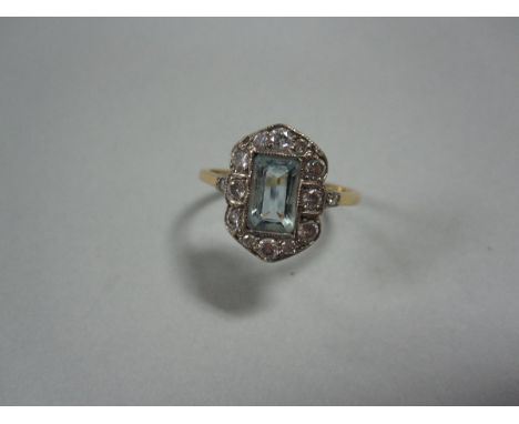 An Art Deco aquamarine and diamond ring, set with an emerald cut aquamarine in a rectangular millegrain collet and a hexagona