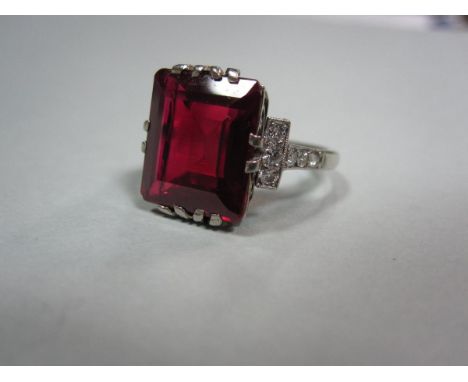 A mid-20th century synthetic ruby and diamond ring, the large step cut ruby multiple claw set to an integral fancy gallery, b