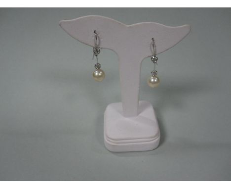 A pair of diamond earrings with removable diamond and pearl drops, each hook terminating to the front with a collet set round