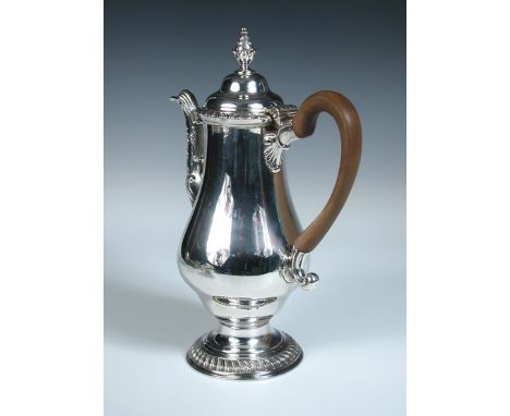 A George III silver coffee pot, by Thomas Wallis I, London 1780, of plain baluster form raised from a gadrooned foot, wooden 