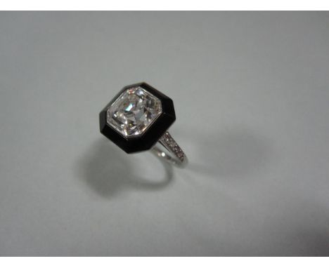 An art deco Asscher cut diamond and onyx ring, the octagonal asscher cut diamond, estimated weight 2.61cts, collet set within