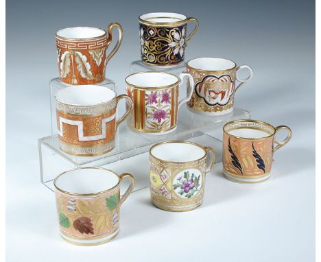 Eight early 19th century coffee cans, each profusely decorated with floral and scroll patterns highlighted in gilt, including