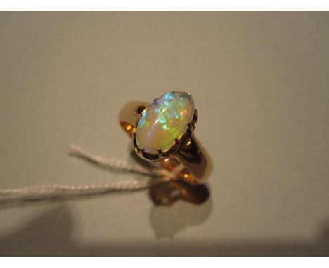 A gold and opal single stone ring, the oval cabochon opal displaying bright and full spectrum play-of-colour, multiple claw s