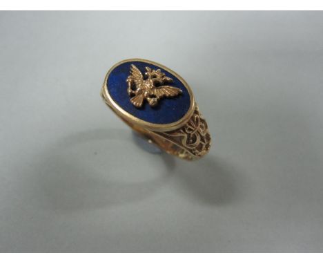 A gold and lapis lazuli ring with double-headed eagle crest, the oval lapis plaque in collet setting with a gold crowned doub