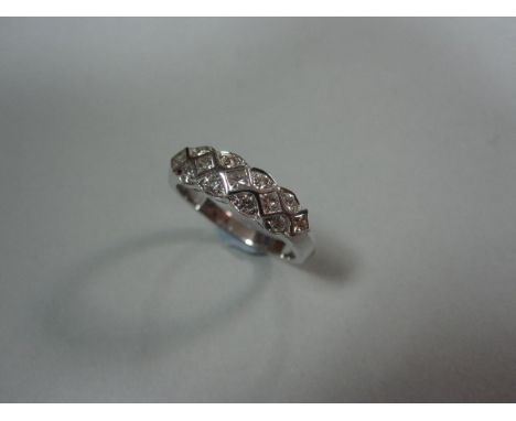 A diamond half-band ring, the tapered chevron-angled shank set to the front with a zig-zag pattern formed by five diaper set 