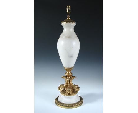 A gilt brass mounted alabaster table lamp, the baluster form raised on four dolphin base and stepped circular foot 68cm (27in