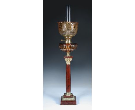 A rouge marble and ormolu mounted oil lamp, the acid etched shade and clear chimney above an amber flash reserve supported on