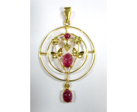 An Edwardian style ruby pendant, designed as concentric hoops with a floral motif in the centre set with a round and an oval 
