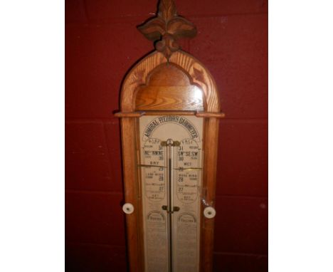 An oak Admiral Fitzroy barometer, late 19th century, the arched case with glazed front displaying paper dial, twin verniers a