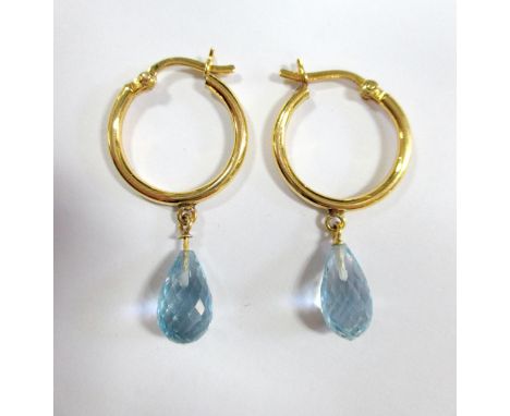 A pair of briolette cut blue topaz ear hoops, each designed as a 1.8cm diameter hoop of unmarked yellow precious metal, with 