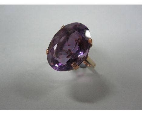 A single stone amethyst dress ring, the large oval cut amethyst in a four claw setting to plain linear gallery and shank of u