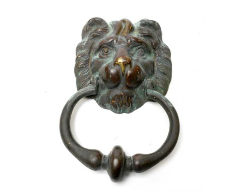A patinated brass lion mask door knocker, 22cms high. 