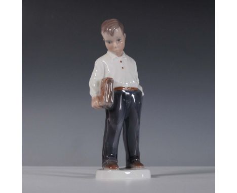 This Lyngby Porcelain figurine, titled Boy with Briefcase, depicts a young schoolboy standing thoughtfully while holding his 