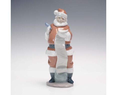 Crafted by Lladro and sculpted by Juan Huerta, this charming porcelain figurine titled Santa's List captures the holiday spir