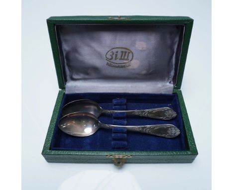 A vintage pair of Soviet silver-plated teaspoons, featuring intricate floral and foliate engravings along the handles, exempl