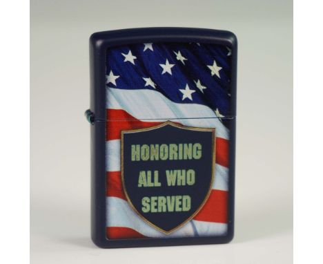 Zippo lighter featuring a dark blue metal case decorated with an American flag backdrop and a shield emblem reading "Honoring