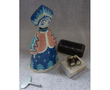 A VINTAGE TINPLATE CLOCKWORK TOY of a woman on wheels, a 19th century snuff box and a pair of miniature binoculars containing