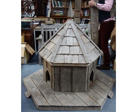 AN OAK DUCK HOUSE of hexagonal form with three Gothic openings, pyramidal shingled roof with finial on a boarded base with th
