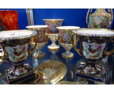 THREE EARLY 19TH CENTURY CERAMIC URNS, decorated with botanical sprays within a gilt border and a pair of Royal blue and gilt