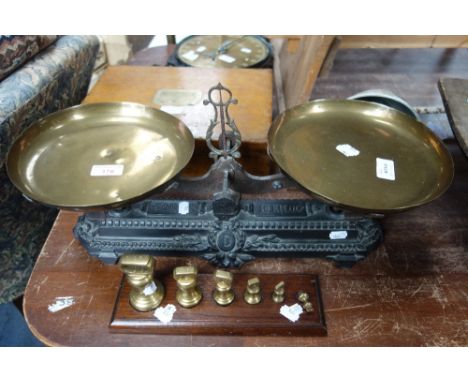 A SET OF 19TH CENTURY CAST IRON BALANCE SCALES with brass pans embossed 'B D', with a set of six graduated brass bell weights