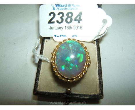 A Weir & Sons 18ct Gold Ring set with a large oval Opal in a rope twist surround and with small diamond to either side.  Size