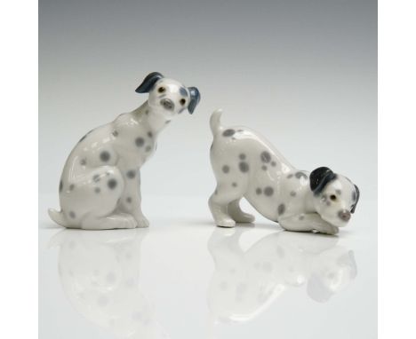 A pair of charming Lladro porcelain figurines featuring Dalmatian puppies in playful poses. Model #1001261 depicts a seated D