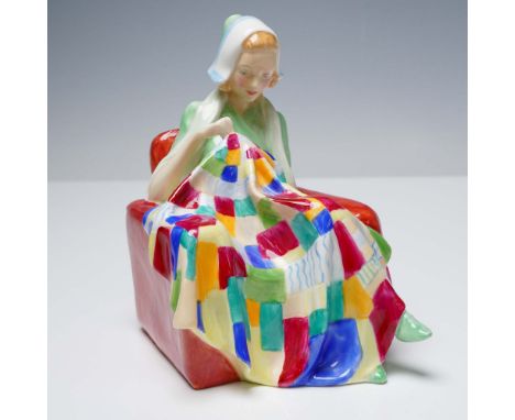 This delightful Royal Doulton figurine titled The Patchwork Quilt (HN1984) captures a serene domestic scene of a young woman 