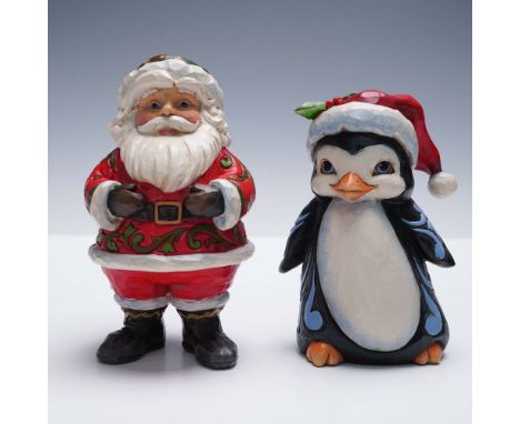 Pair of festive Jim Shore Heartwood Creek hand-painted figurines featuring a cheerful Santa Claus and a jolly penguin, both w