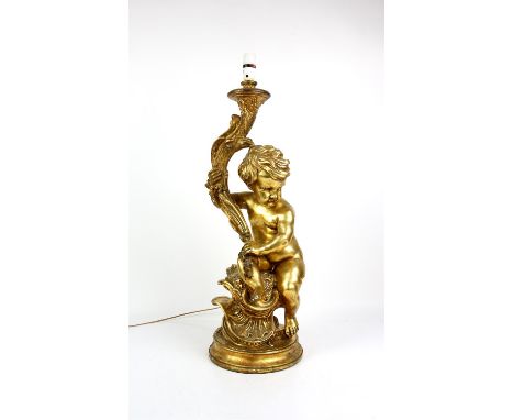 Large gilt plaster table lamp, in the form of a cherub holding a torch, 67 cm high, with shade