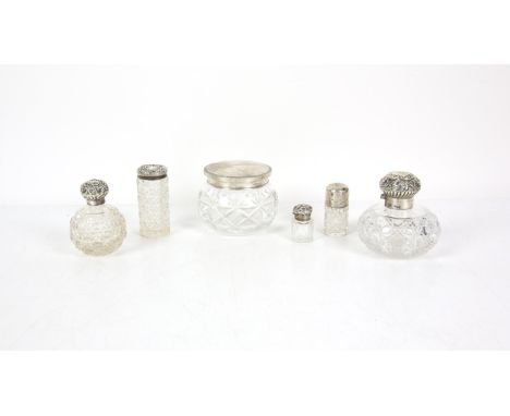 Four cut glass and silver topped scent bottles of various sizes and hallmarks, largest 9.5cm high, together with a glass dres