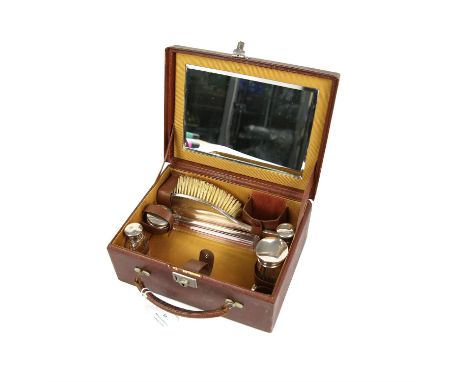 Gentleman's brown leather dressing case, the interior fitted with a mirror, two silver topped  bottles, two silver toped jars